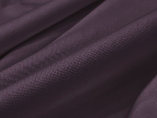 Smooth, folded dark purple fabric with soft bedsheet