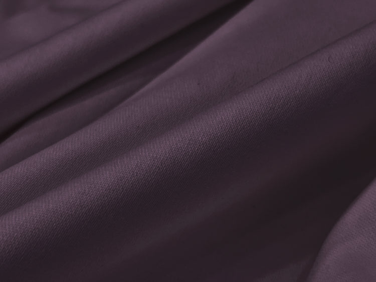 Smooth, folded dark purple fabric with soft bedsheet
