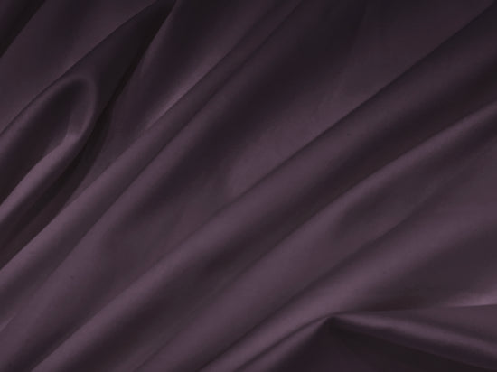 Smooth, folded dark purple fabric with soft shadows creates a rich, elegant texture. 