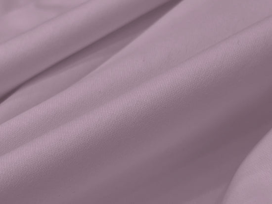Smooth lavender fabric folds create an elegant, soft texture, suggesting comfort and luxury