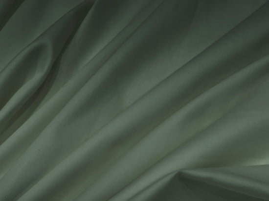 Smooth, light gray satin fabric with gentle folds and shadows, creating a soft, elegant texture.