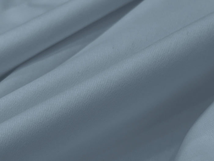 Smooth, light grey fabric with soft folds and gentle shadows.
