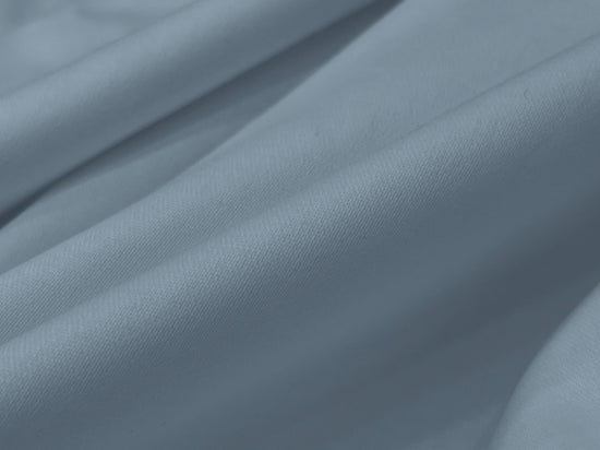 Smooth, light grey fabric with soft folds and gentle shadows.