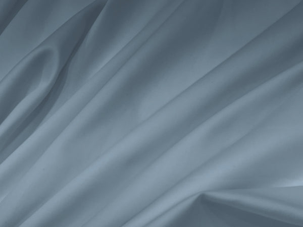 Smooth, soft folds of light gray fabric create a serene.