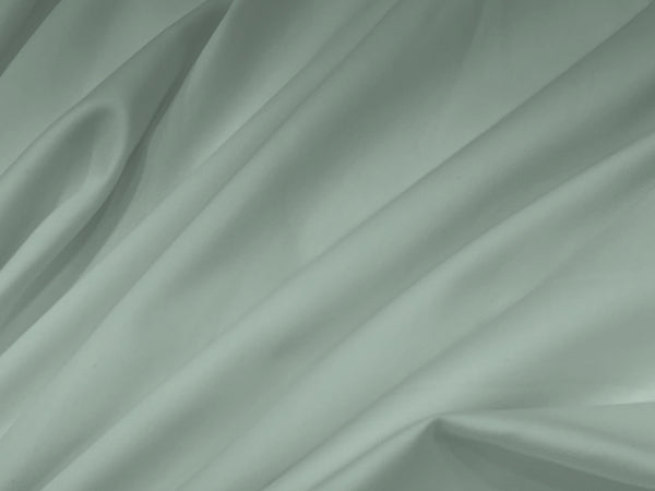 Soft green fabric bedsheet with smooth folds and gentle shadows.