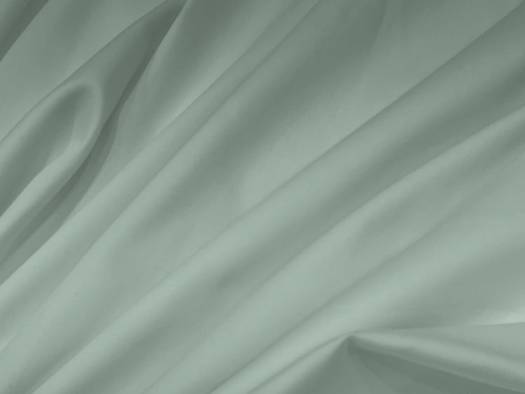 Soft green fabric bedsheet with smooth folds and gentle shadows.