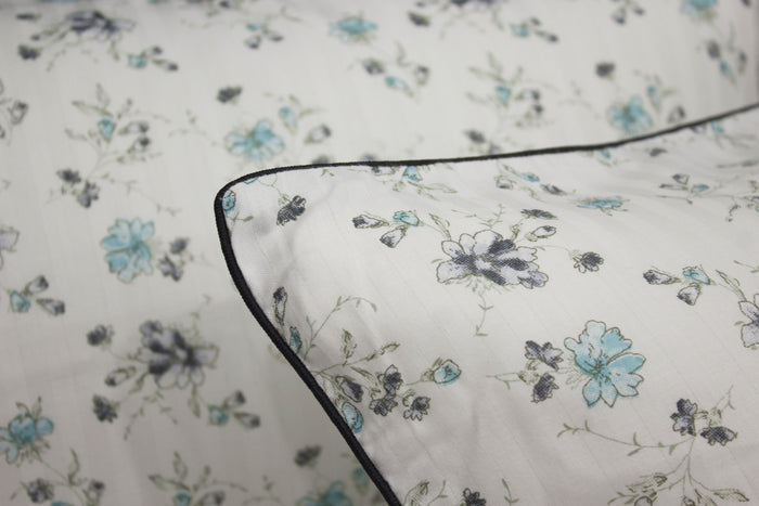 bedsheet and  pillow with a floral print design, shades of blue and green .