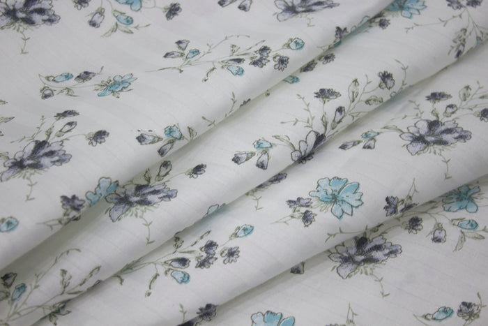 bedsheet  with a floral print design, shades of blue and green neatly folded .