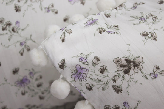 bedsheet with pillow floral print and purple stripes on a bed.