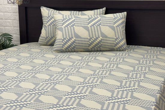 bedsheetand matching pillows featuring geometric blue and beige designs. 