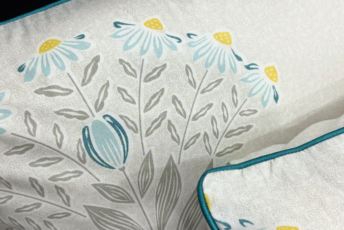 custom bed sheet with pillow in shades of grey, yellow, and blue with a floral print design.