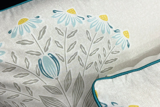 custom bed sheet with pillow in shades of grey, yellow, and blue with a floral print design.