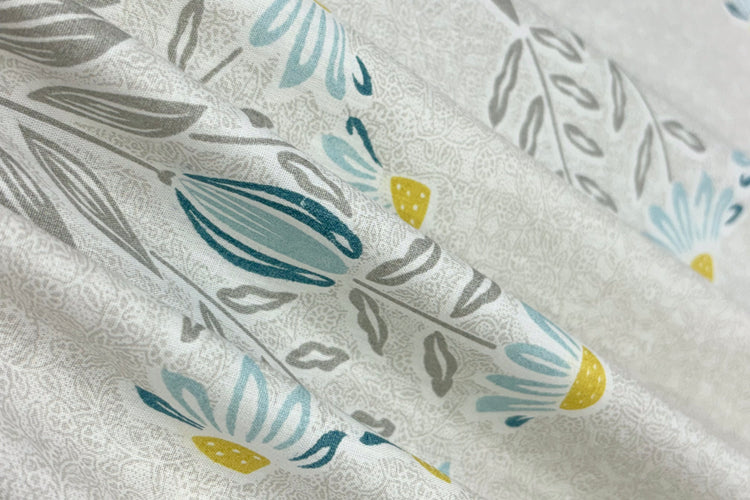 custom bed sheet with shades of grey, yellow, and blue with a floral print design.