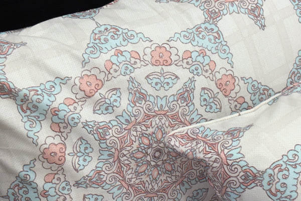 pillows with geometric patterns in shades of white, blue, and pink.