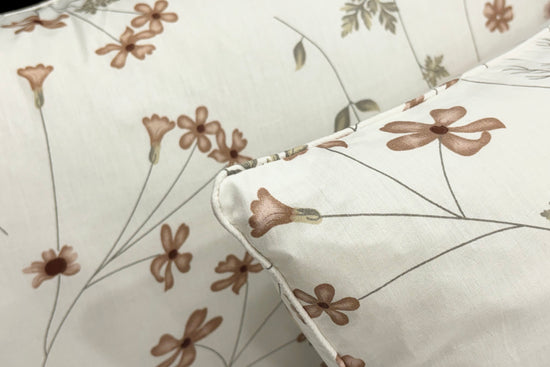  white and brown floral print pillow neatly arranged on a bed