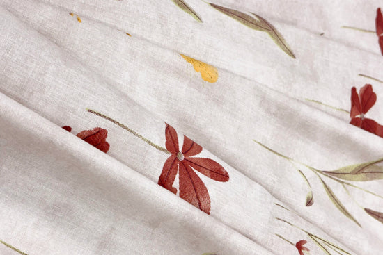 white cotton bedsheet with  floral print arranged on bed  