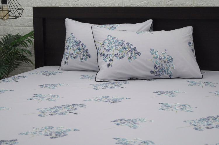 A set of two pillows with a floral print design bedsheet in shades of purple 2
