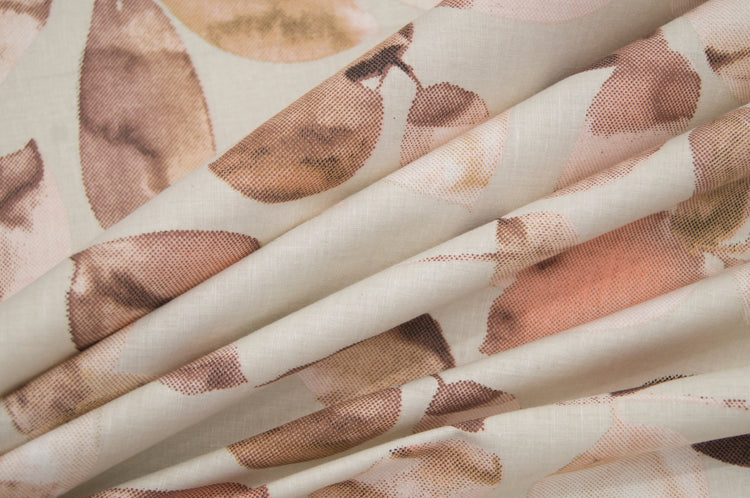 Custom bed sheet with a leaves print in shades of brown softly folded.