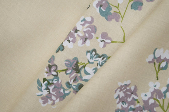 bedsheet with floral patterns, featuring small purple and green flowers.